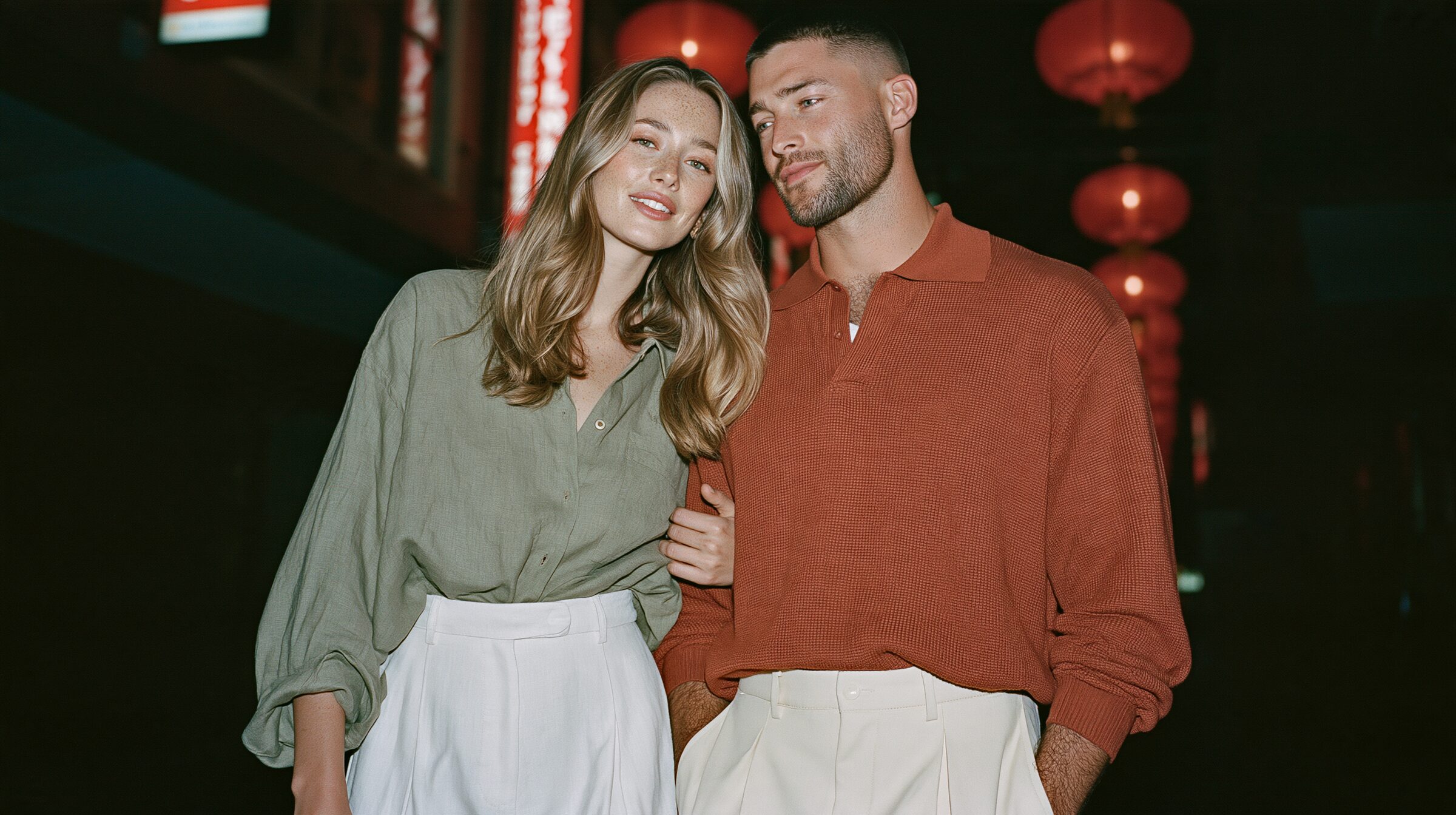 Couple walking arm in arm beneath glowing red lanterns on Little Bourke Street in Chinatown at night