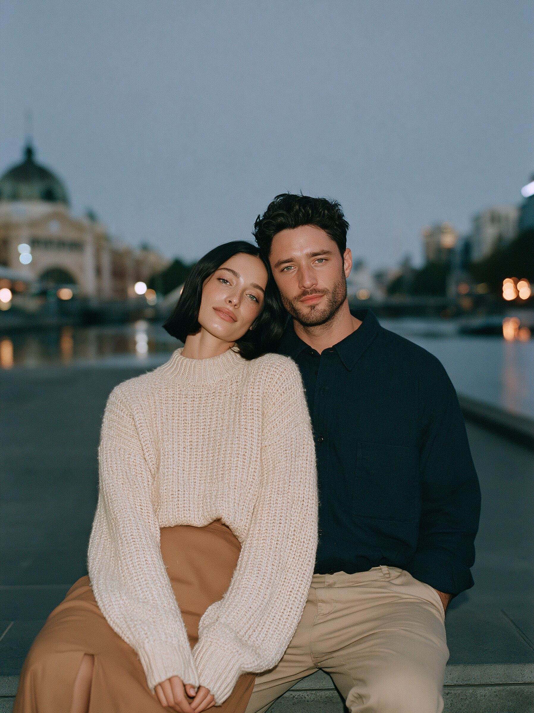 Couple sitting close on the stone steps of the Yarra River promenade at dusk