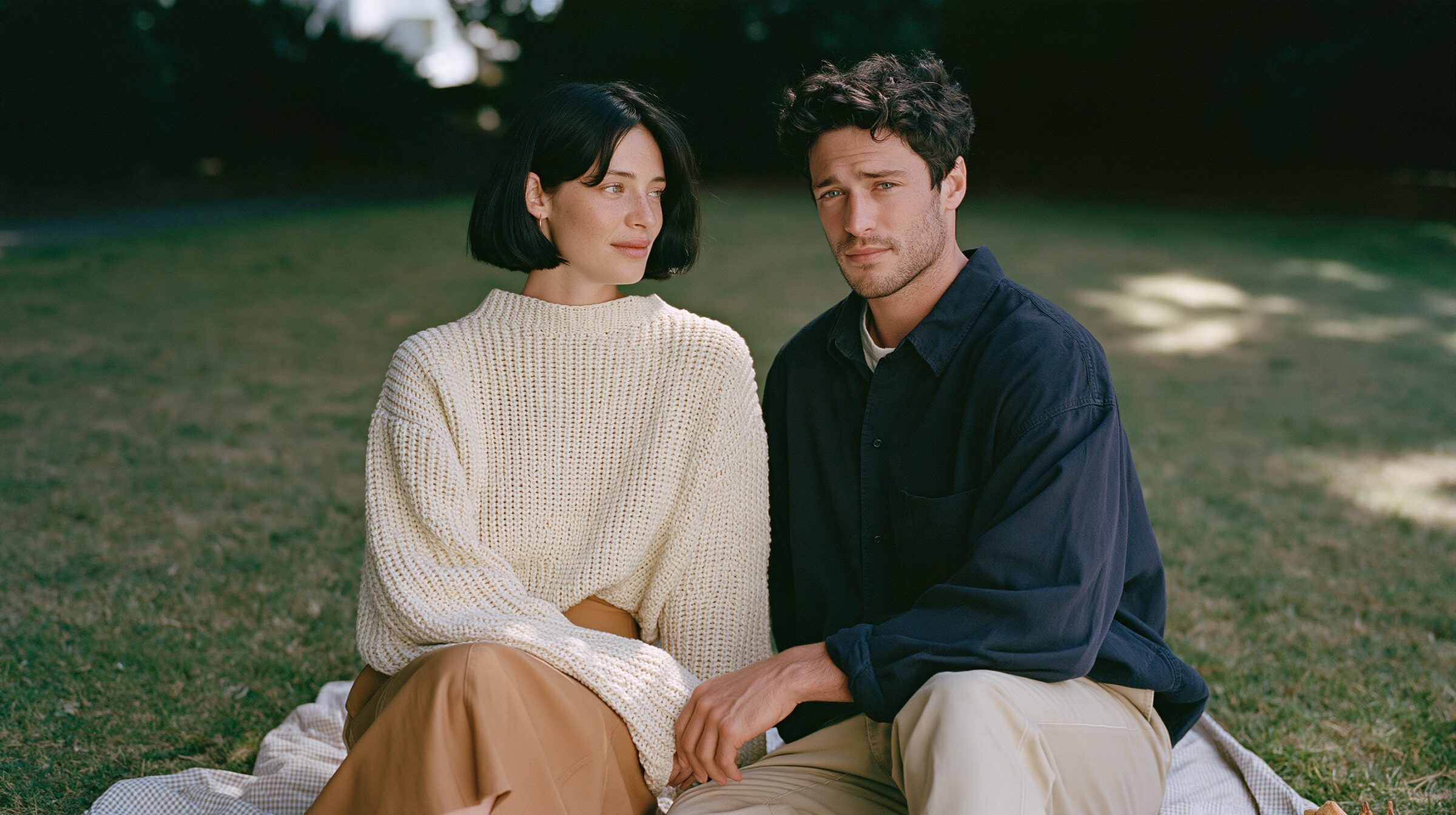 Couple sharing a picnic on a checkered blanket on the lawns of the Royal Botanic Gardens