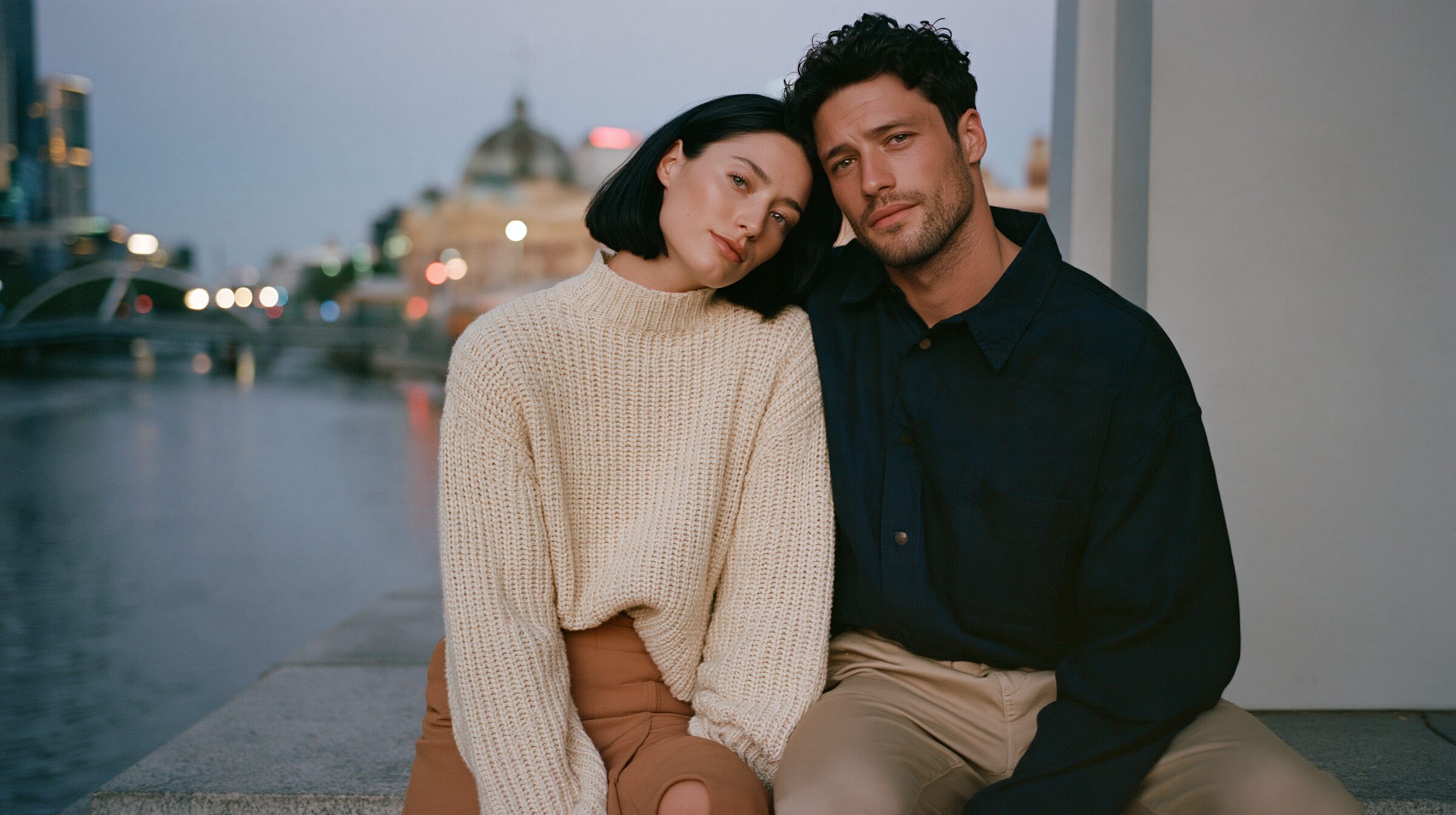 Couple sitting close on the stone steps of the Yarra River promenade at dusk