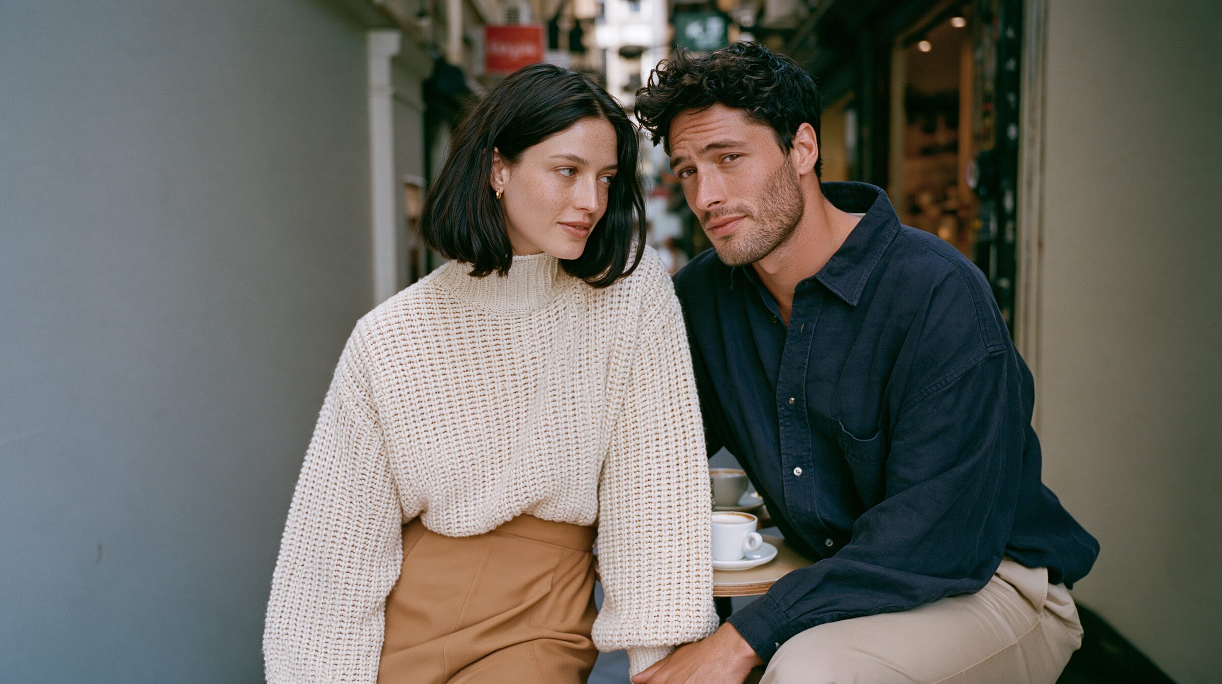 Couple sharing flat whites at a tiny café table in Degraves Street laneway